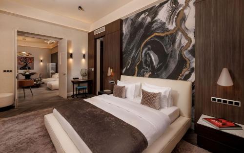 巴拉顿菲赖德Anna Grand Hotel的一间卧室配有一张大床,墙上挂着一幅大画