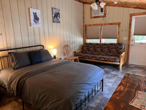 奥沙克湖Buddy's Harbor的一间卧室配有一张床和一张沙发