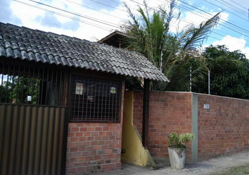 格拉瓦塔Casa 04 do Condomínio Privê Portal das Flores的砖屋,有墙和围栏