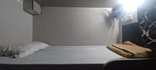 孟买New Passenger Dormitory的卧室配有一张带聚光灯的白色床