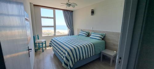 斯科特堡Sun Sea Sand Peacehaven Scottburgh的一间卧室设有一张床,享有海景