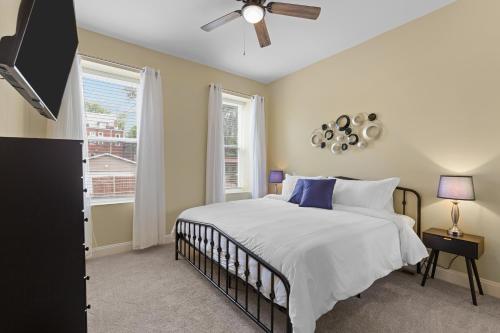 SoulardChic 4-Bed Home near Attractions - JZ Vacation Rentals的一间卧室配有一张床和吊扇