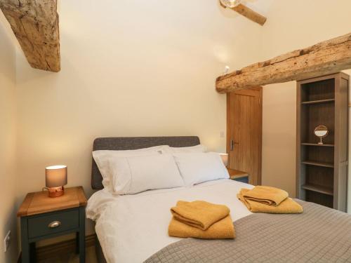科舍姆Chequers Barn的一间卧室配有一张床,上面有两条毛巾