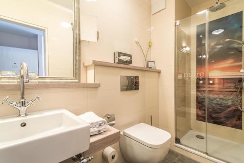 朗格奥Suiten-Hotel mare Langeoog的一间带水槽、卫生间和淋浴的浴室