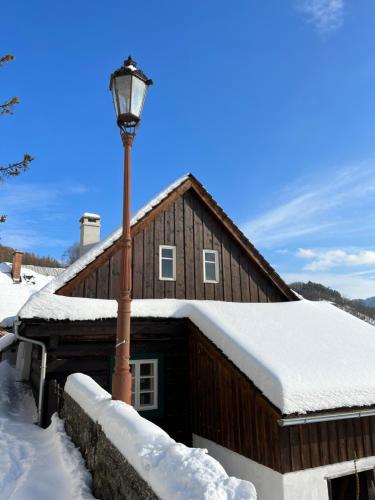 什特兰贝尔克Santova roubenka的雪中的房子,有街灯