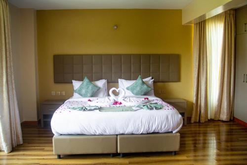 MauaSpringWells Hotel ltd的一间卧室配有一张白色大床,床上有鲜花