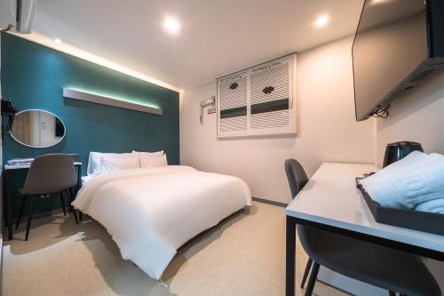仁川市Hotel Centro Stay的卧室配有白色的床、书桌和桌子