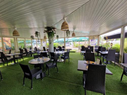 卢森堡BIVIUS Hotel Restaurant Luxembourg的用餐室设有桌椅和窗户。