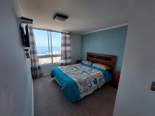 伊基克LABBE Departamento Hermosa Vista al Mar的一间卧室设有一张床和一个大窗户