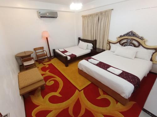 塔奈Casa de Robles Tanay Rizal的酒店客房,设有两张床和一张桌子及椅子