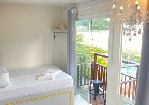 佩尼亚Pousada São Miguel Beach Beira Mar的客房设有一张床和一个美景阳台