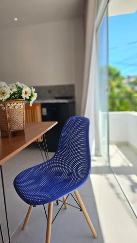 伊塔卡雷Estúdio Arruda的一张蓝色椅子,坐在木桌旁