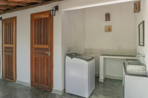Praia dos AlgodõesGlamping Coco Dendê - Algodões的洗衣房配有洗衣机和木门