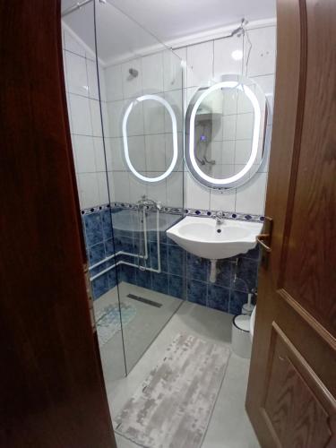 佩奇Pejë的一间带水槽和两面镜子的浴室