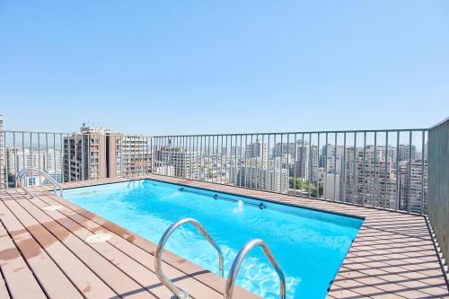 圣地亚哥Departamento 2 dormitorios 2 baños + parking的城市天际线阳台的游泳池