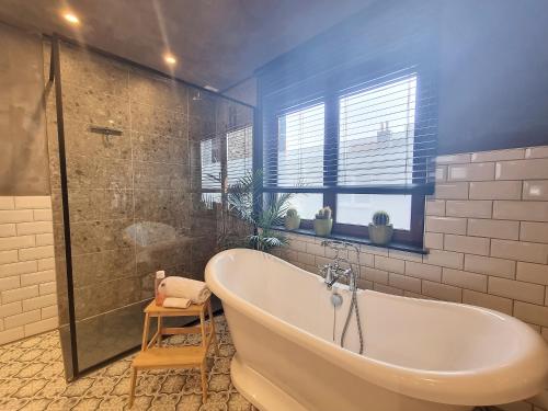 尼乌波特Dream@coast的带浴缸和玻璃淋浴间的浴室。