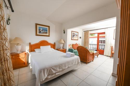 奥拉涅斯塔德E Solo Aruba Apartments的卧室配有床、椅子和窗户。
