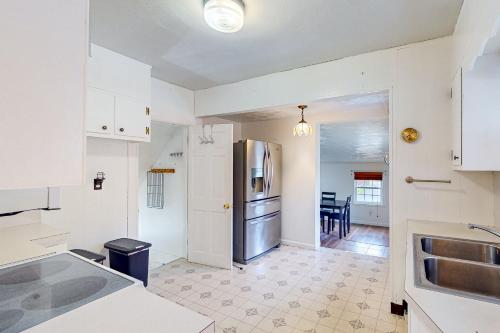 OdentonPerch Between Cities的厨房配有白色橱柜和不锈钢冰箱