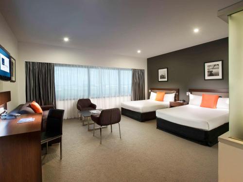 布里斯班布里斯班机场诺富特酒店的酒店客房配有两张床和一张书桌