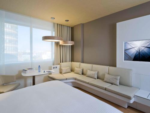 布鲁塞尔布鲁塞尔中心铂尔曼酒店 的客厅配有白色的沙发和桌子