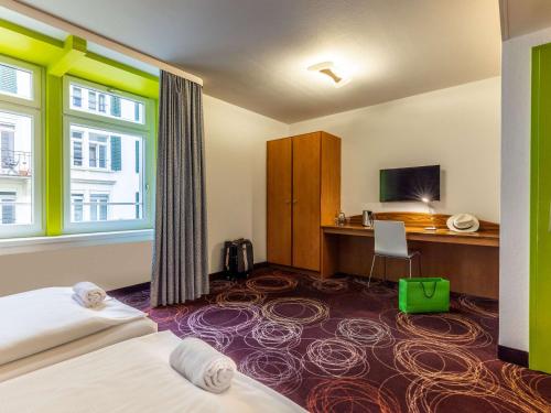 卢塞恩卢塞恩宜必思尚品酒店的配有一张床和一张书桌的酒店客房