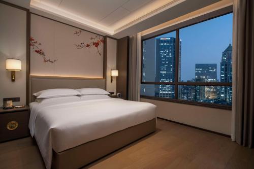 广州广州越秀宾馆，希尔顿格芮精选酒店 - 广交会期间免费往返广交会穿梭巴士的一间卧室设有一张大床和一个大窗户