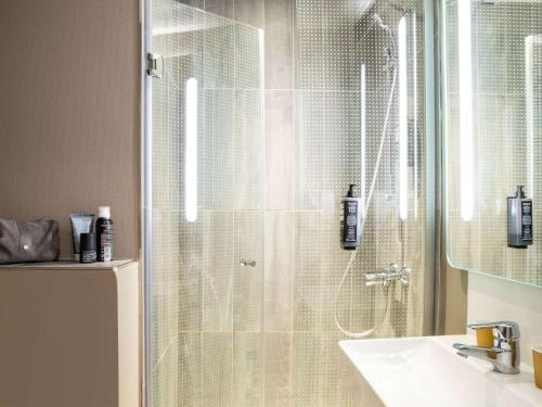 巴黎巴黎蒙马特北18区奥纳诺宜必思酒店的一间带玻璃淋浴间和水槽的浴室