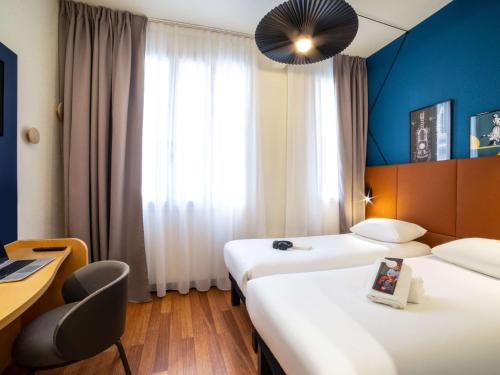 巴黎巴黎蒙马特北18区奥纳诺宜必思酒店的酒店客房配有两张床和一张书桌