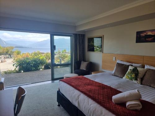 莫阿纳布伦纳湖酒店的一间卧室设有一张大床和一个大窗户