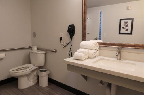 凤凰城格林豪泰凤凰城天港机场套房酒店的一间带卫生间、水槽和电话的浴室