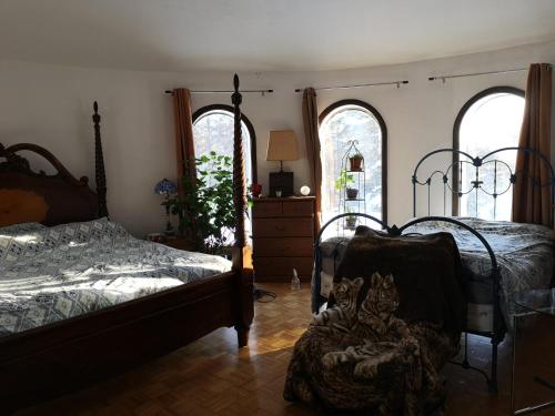 瓦尔达维德La Templière的一间卧室设有两张床、一个梳妆台和两个窗户。