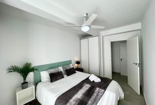 阿勒纳勒斯德尔索尔Arenales del sol, primera linea de playa的一间卧室配有一张床和吊扇