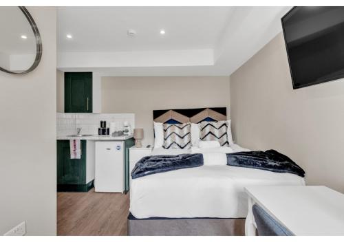 伦敦Stay & Explore: Convenient Studio - Prime Location的一间带白色大床的卧室和一间厨房