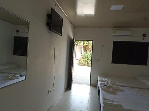 特里温福港Alojamiento la esmeralda的一间设有两张床和一台墙上电视的房间