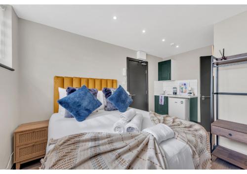 伦敦Get Your Zen On: Relaxing Studio in Central的一间卧室配有一张带蓝色枕头的床。