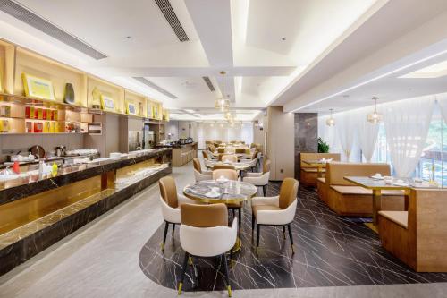 深圳深圳富邦国际酒店(南山科技园店)的一间带桌椅的餐厅和一间酒吧