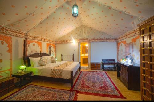 斋沙默尔Lakhina Heritage desert camp的壁纸客房内的一间卧室配有一张床