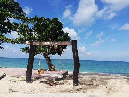 高兰Beach Bungalow at Lanta Resort的海滩上的秋千和一棵树