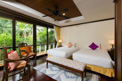卡塔海滩Katamanda Villa Chanti的一间带两张床的卧室和一个阳台