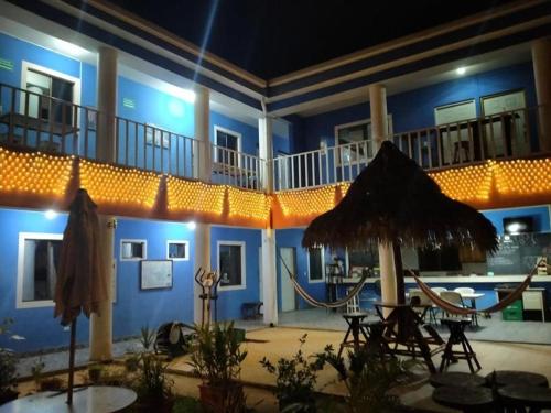 马那瓜Montecristi Hotel Near the Nicaragua Intl Airport的蓝色的建筑,设有配有桌子和雨伞的庭院