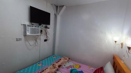 马尼拉MJ Home的小房间设有床铺和电视