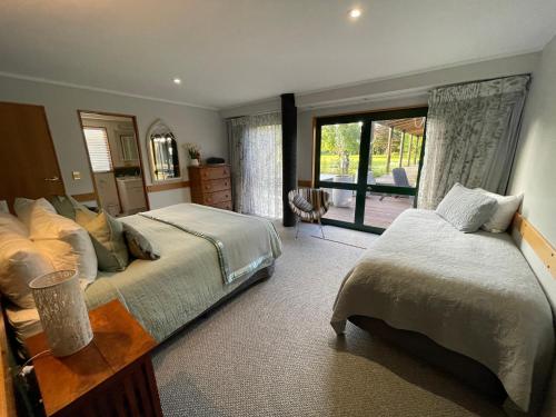 罗托鲁瓦Tikitere Lodge, Rotorua的一间卧室设有两张床和大窗户