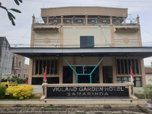 沙马林达Violand Garden Hotel Samarinda的建筑前有标志的酒店