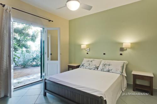 Kyra PanagiaRigò Apartments的一间卧室设有一张床和一个滑动玻璃门