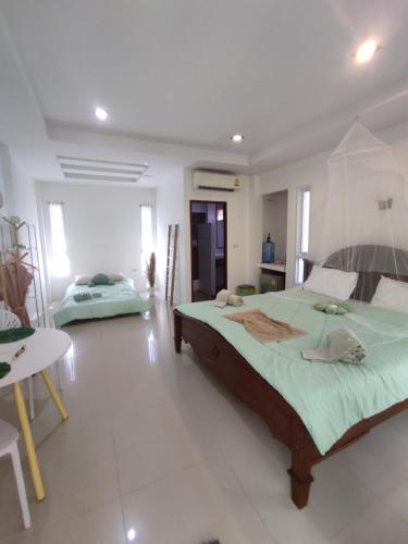 Ban Mo NaeLuana Villas的一间卧室配有一张大床和一张桌子