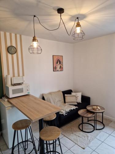 科尔尼蒙Bel appartement rénové (Le Nichoir)的客厅配有沙发和桌子