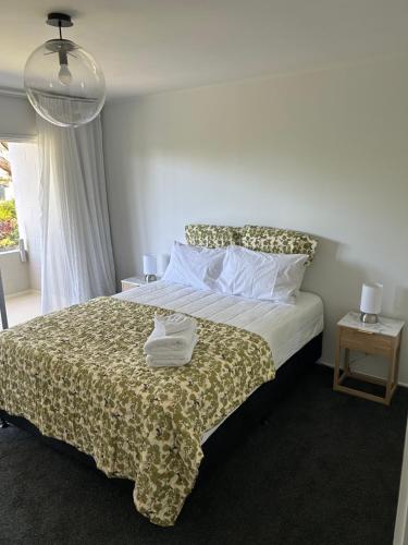 奥克兰Central Howick Uxbridge Apartments的一间卧室配有一张带被子和枕头的床