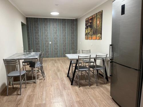 阿拉木图Hostel Nomad的客房配有桌椅和冰箱。