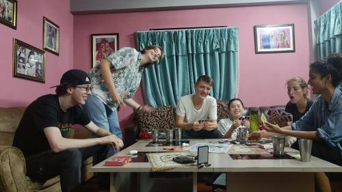 KirtipurKIRTIPUR COMFORT HOMESTAY with breakfast & dinner的一群人坐在一个房间里桌子旁