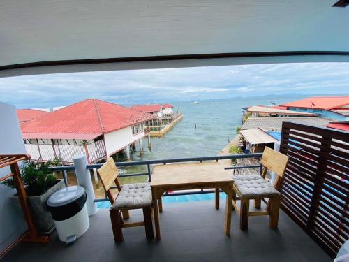 格兰岛บ้านพักการ์ฟิลด์ ซีวิว เกาะล้าน的一个带桌椅的海景阳台